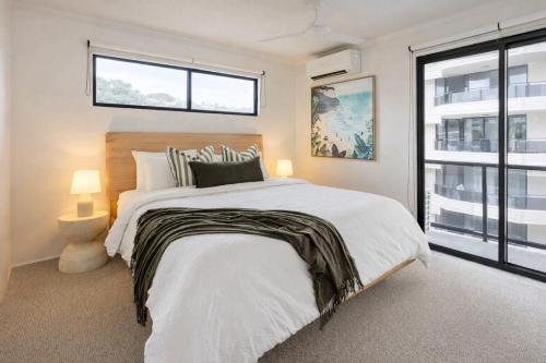 a bedroom with a large bed and a window at Summer Cove on the Ocean with Pool in Coolum Beach