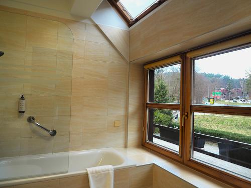 a bathroom with a bath tub and a window at Dom Oliwski in Gdańsk