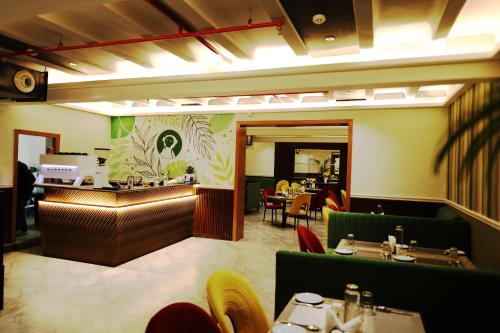 a restaurant with a dining room with tables and chairs at asar Capoors Hotel Hazratganj by Orion Hotels in Lucknow
