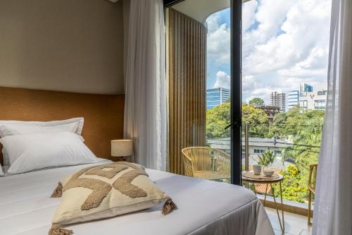 a bedroom with a bed and a large window at WELL Residences - By AVA Rentals in Asunción
