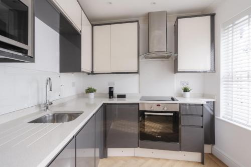 a white kitchen with a sink and a stove at Glebe Road in Chelmsford