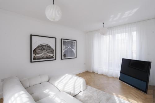 a white living room with a white couch and a tv at Glebe Road in Chelmsford