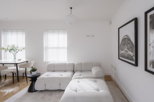 a white living room with a white couch and a table at Glebe Road in Chelmsford