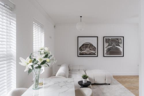 a white living room with a vase of flowers on a table at Glebe Road in Chelmsford