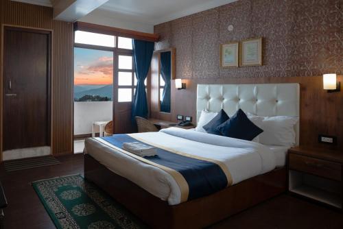 a hotel room with a large bed and a window at The Di-Lac Retreat in Gangtok