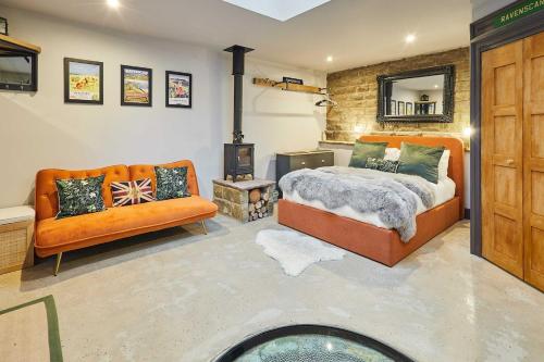 a bedroom with a bed and a couch and a fireplace at The Churchside Well in Ravenscar
