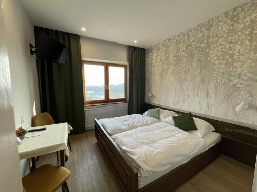 a bedroom with a bed and a desk and a window at Naglhof in Gottsdorf