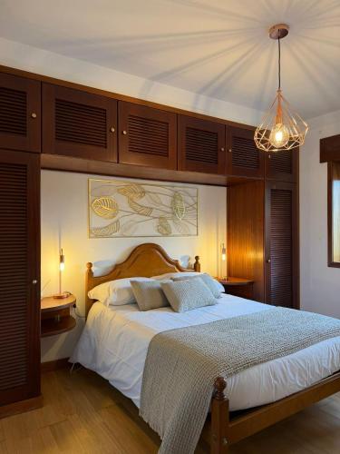 a bedroom with a large bed and a chandelier at Quintinha de Sabadim - 500 metros da ecovia de Sistelo in Arcos de Valdevez