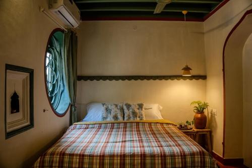 a bedroom with a bed with a plaid blanket at Luxury 3BHK Pool Villa Near Beach Pondicherry in Pondicherry