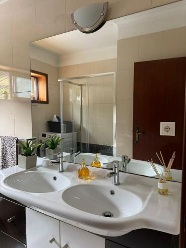 a bathroom with two sinks and a large mirror at Quintinha de Sabadim - 500 metros da ecovia de Sistelo in Arcos de Valdevez