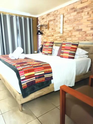 a bedroom with a large bed with white sheets and pillows at PROSERPINE MOTOR LODGE in Proserpine