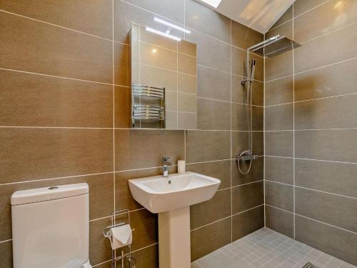 a bathroom with a sink and a toilet and a mirror at 1 Bed in Halifax oc-90213 in Sowerby Bridge