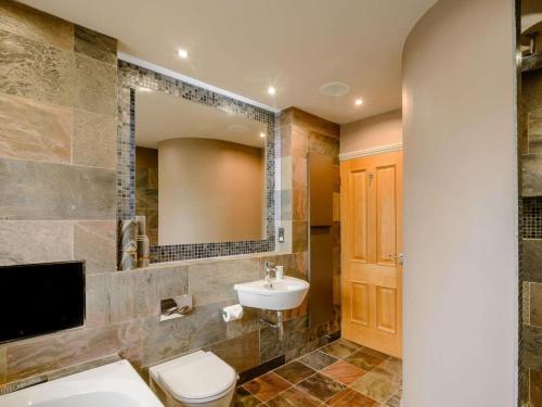 a bathroom with a sink and a toilet and a mirror at 3 Bed in Halifax oc-90209 in Sowerby Bridge