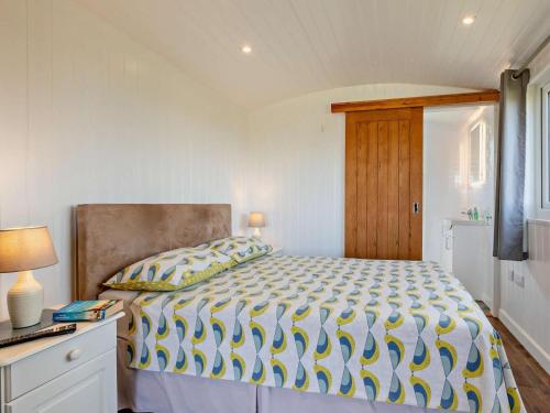 a bedroom with a bed with a yellow and white comforter at 1 Bed in Bridport oc-90055 in Whitchurch Canonicorum