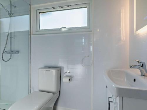 a white bathroom with a toilet and a sink at 1 Bed in Bridport oc-90055 in Whitchurch Canonicorum