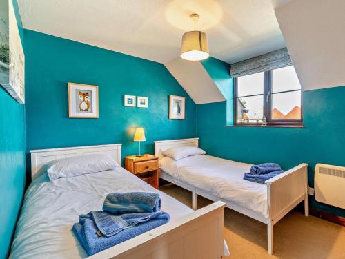 two beds in a room with blue walls at 3 Bed in Bude oc-trvvv in Poughill