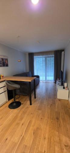 a living room with a table and a couch at Kurzemes Pērle Beach Apartament - Albatross in Ķesterciems