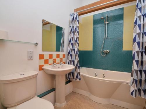 a bathroom with a sink and a toilet and a tub at 2 Bed in Sherborne oc-folwo in Long Burton