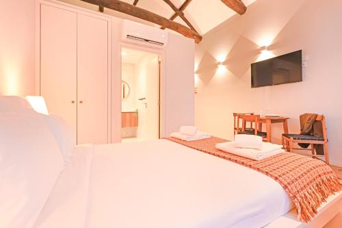 a white bedroom with a large bed and a table at FindMe InPorto Bonfim in Porto