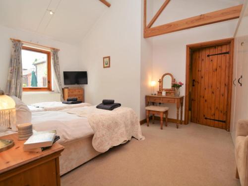 a bedroom with a bed and a desk and a television at 2 Bed in Sherborne oc-folwo in Long Burton