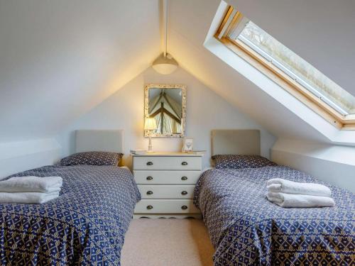 a attic bedroom with two beds and a mirror at 2 Bed in Radstock oc-00452 in Binegar