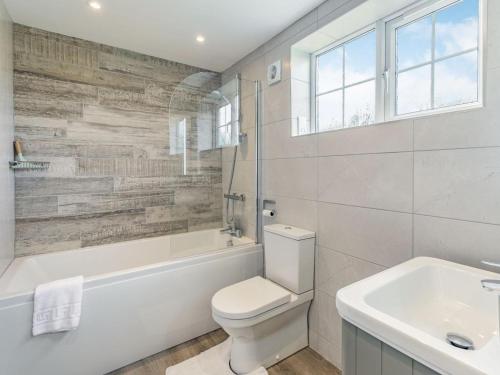 a bathroom with a toilet and a tub and a sink at 2 Bed in York oc-84001 in Crayke