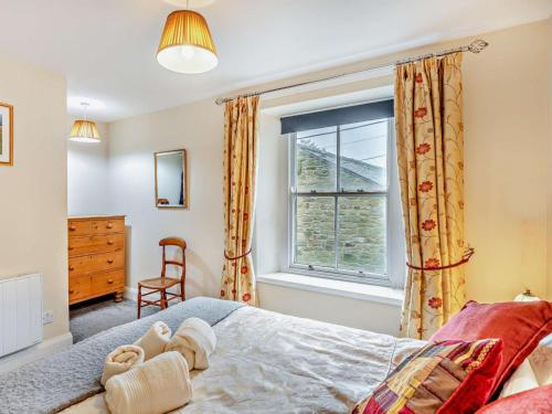 a bedroom with a bed with a window and a chair at 2 Bed in Hexham oc-50500 in Bellingham