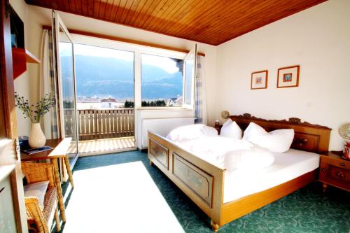 a bedroom with a bed and a large window at Hotel Sonnleitn in Jenig