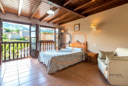 a bedroom in a villa with a bed and a balcony at Casa Rural La Indiana I y II in Porrúa