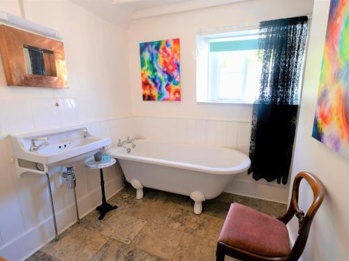 a bathroom with a sink and a bath tub and a sink at 4 Bed in Godshill oc-ic034 in Godshill