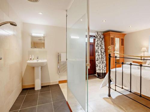 a bathroom with a shower and a sink and a bed at 4 Bed in Frome oc-27808 in Holwell