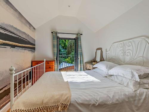 a bedroom with a large bed and a balcony at 3 Bed in Montacute oc-92227 in Montacute