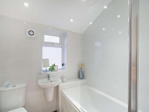 a white bathroom with a toilet and a sink at 3 Bed in Ripon oc-94477 in Ripon