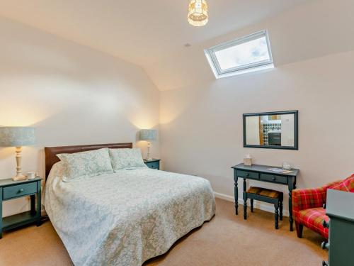 a bedroom with a bed and two tables and a window at 2 Bed in Driffield oc-79280 in Wold Newton