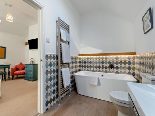 a bathroom with a tub and a toilet and a sink at 2 Bed in Driffield oc-79280 in Wold Newton