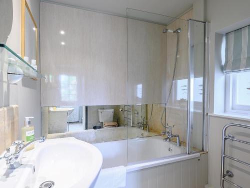 a bathroom with a tub and a sink and a shower at 1 Bed in Brockenhurst oc-78926 in Beaulieu
