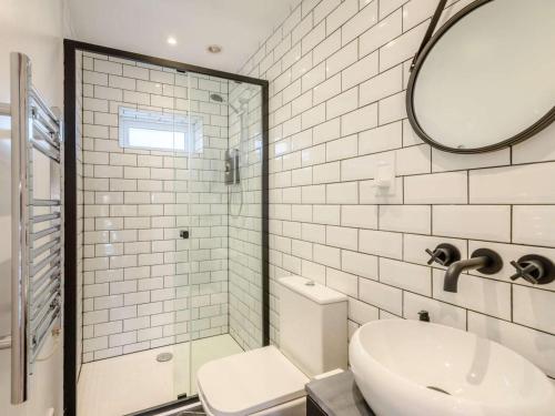 a bathroom with a toilet and a sink and a mirror at 1 Bed in Lymington oc-81429 in Lymington