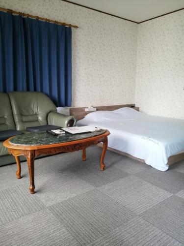 a bedroom with a bed and a coffee table at Minpaku Yamamoto - Vacation STAY 13870 in Izumiotsu