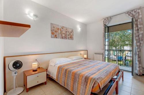 a bedroom with a bed and a large window at Residence La Brughiera Malpensa in Lonate Pozzolo