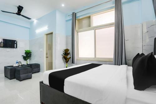 a bedroom with a white bed and a large window at Hotel O Safe & Sure Residency in Gurgaon