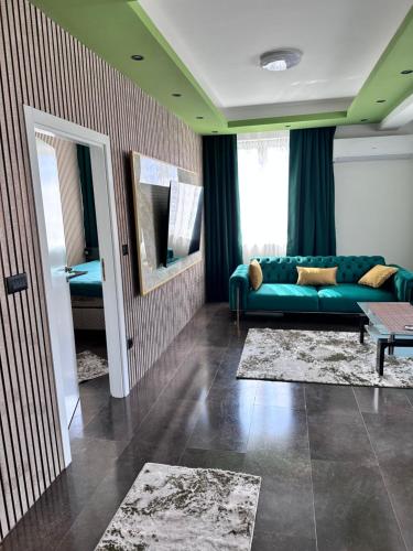 a living room with a green couch and a mirror at Cataleya III in Sarajevo