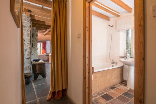 a bathroom with a tub and a toilet and a sink at Crabhall Barn in Haverfordwest