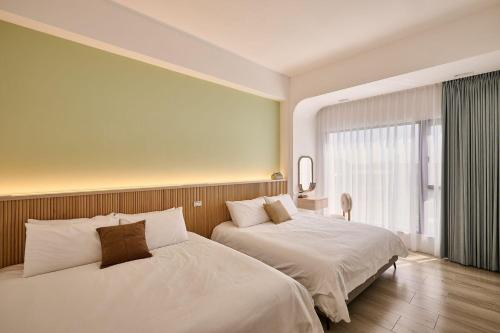 a hotel room with two beds and a window at 藤夏日光 in Weiqian