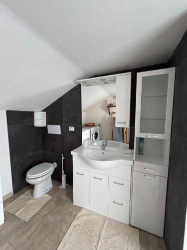 a bathroom with a white sink and a toilet at Gere house in Lezzeno