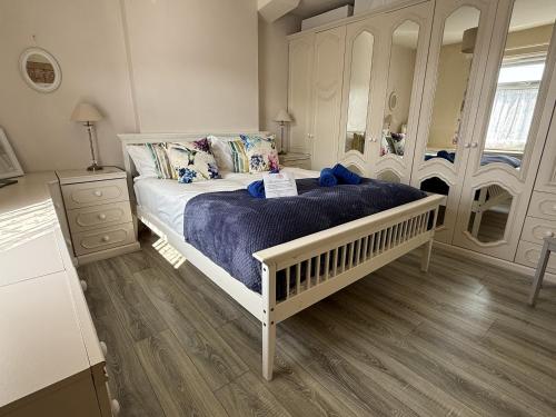 a bedroom with a white bed with a blue blanket at Pembroke Villa in Shanklin