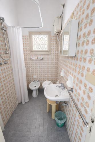 a bathroom with a sink and a toilet at Camere Capinera in Cesenatico