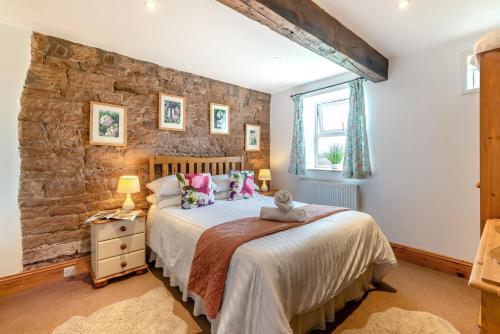 a bedroom with a bed and a stone wall at 3 Bed in Scaleby oc-b33069 in Scaleby