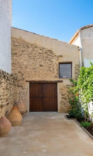 a garage with a wooden door and a building at Casa Rural Las Camilas- Sierra de Alcaraz in Vianos