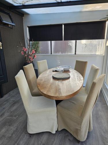 a dining room with a wooden table and chairs at Houten Chalet nabij Beekse Bergen in Hilvarenbeek