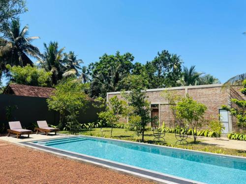 an image of a swimming pool in front of a house at Dhyana Beach Villa in Ambalangoda